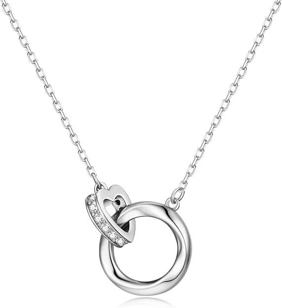 Gold heart‑shaped pendant necklace on a simple jewelry stand